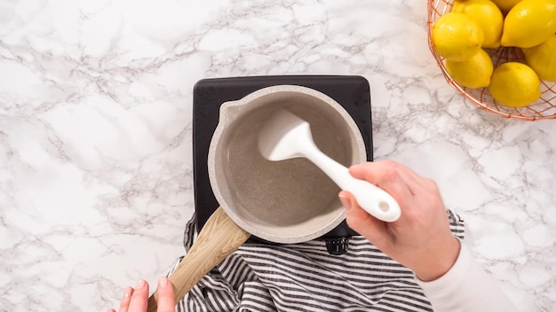 ręka trzymająca łyżkę nad garnkiem